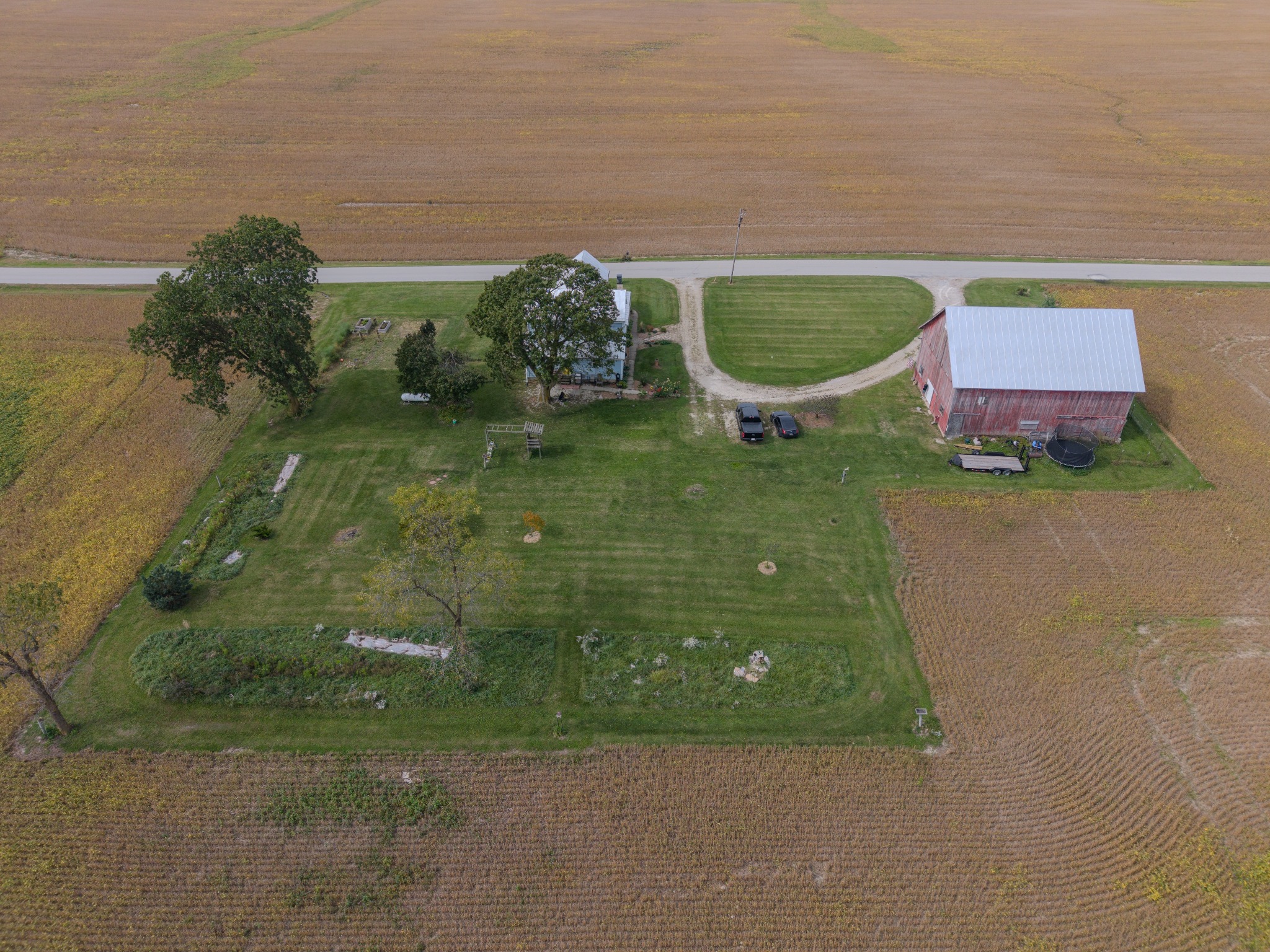 Overhead aerial photograph of a rural home, barn, yard, and road
